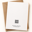 A white stationery card with a black QR code and small printed text at the bottom, placed on top of a brown kraft envelope against a light beige background.