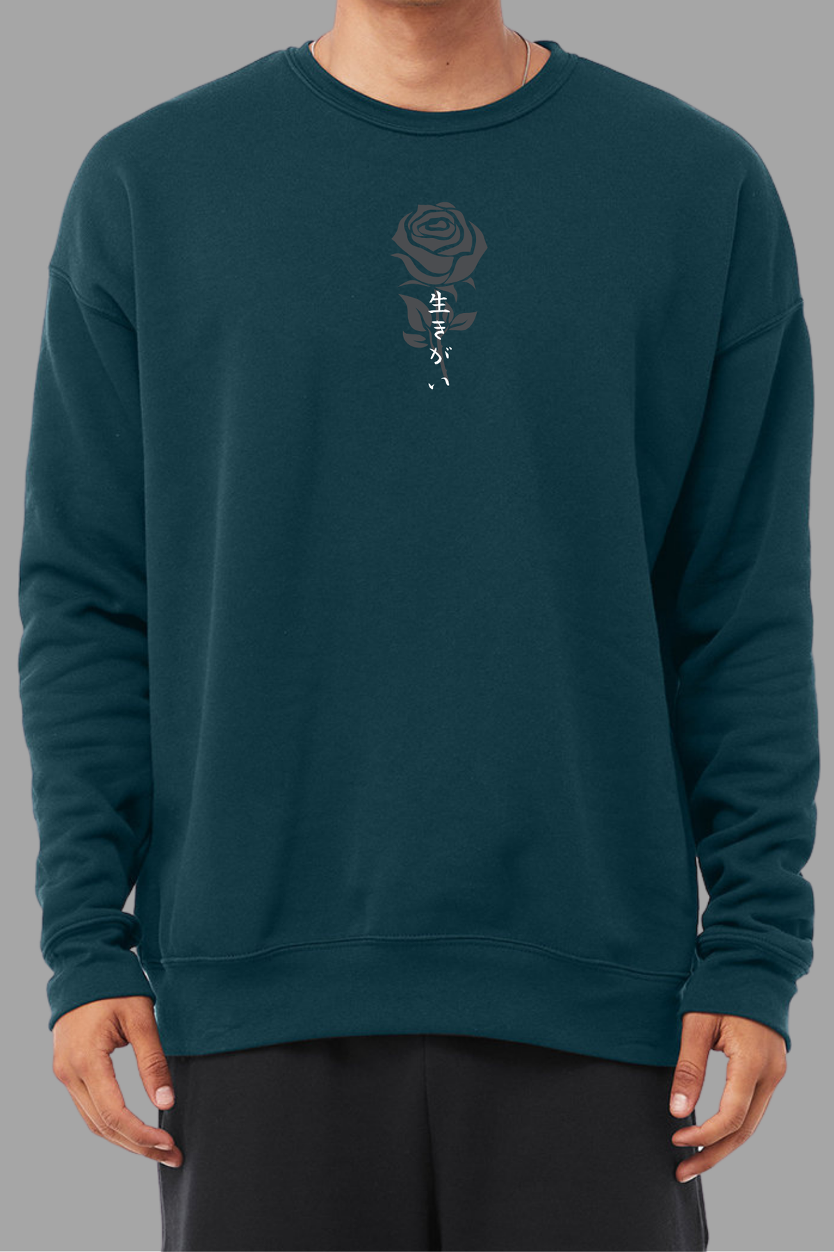 a man wearing a teal sweatshirt with gray rose graphic and japanese text IKIGAI